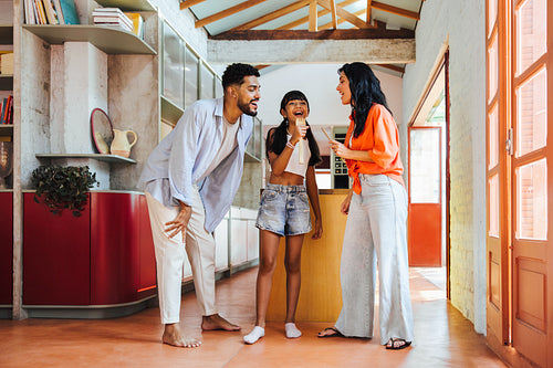 Family enjoying a joyful singing activity together in a modern home setting