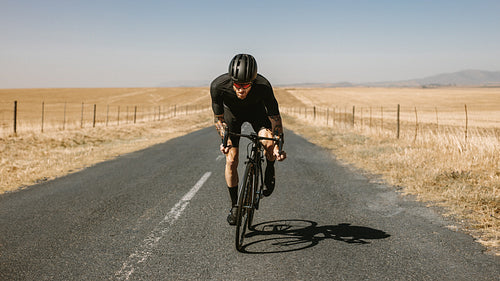 Man riding a bike on open highway in countryside