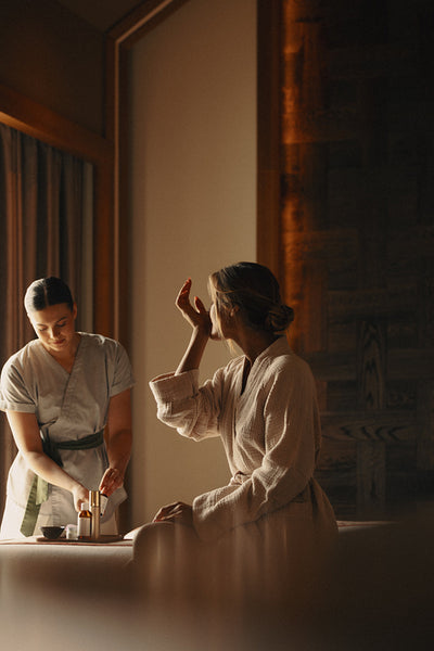 Esthetician providing facial skincare treatment to a client at a serene spa