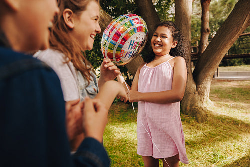 Children celebrating a birthday outdoors with laughter and joy