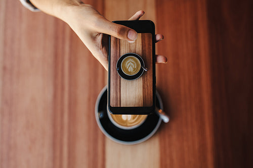 Woman taking a photo of her coffee