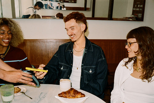 Friends at a cafe sharing contactless payment