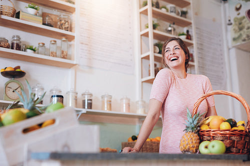 Smiling woman standing at a juice bar counter