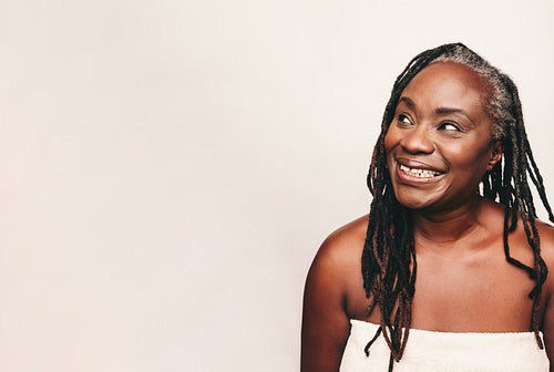 Refreshed woman looking away with a smile in a studio