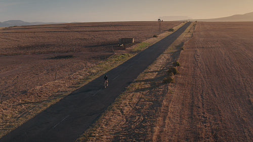 Cyclist riding a cycle on asphalt road in the countryside