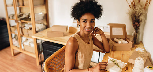 Artist in studio with wrapped jewelry pack for sell