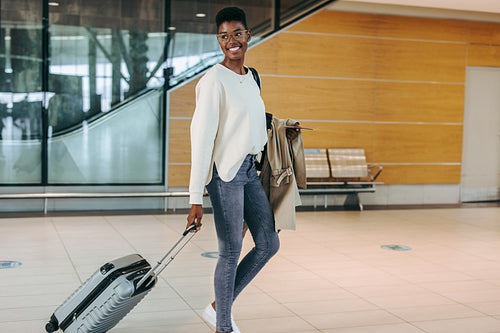 Woman tourist walking with trolley at airport