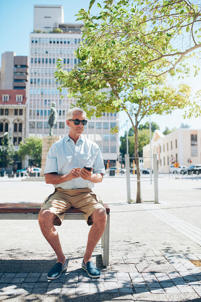 Mature male tourist resting on a city bench 