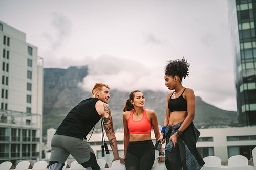 Group of fitness people standing on rooftop after workout