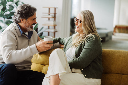 Couple share coffee and conversation on a sofa