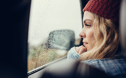 Thoughtful woman travelling by a car