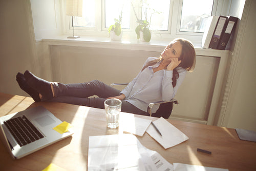 Relaxed businesswoman with legs on the desk