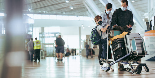 Family at airport waiting for flight in pandemic