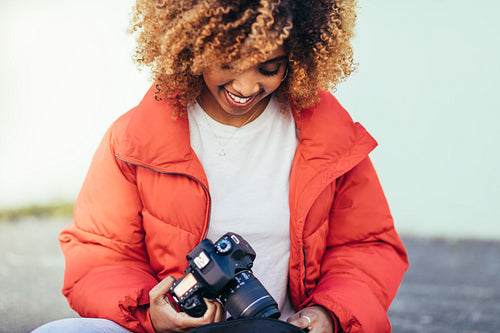 Close up of a female tourist sitting on street with a digital camera