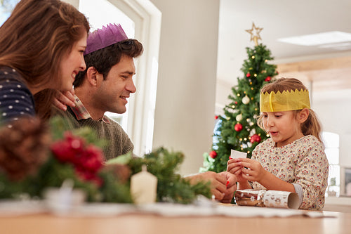 Cute little girl with parents reading her christmas wish list