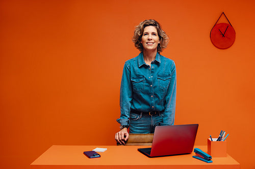 Confident woman working in a home office with colorblocking elements