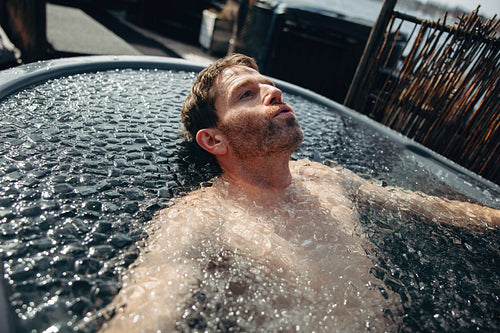 The recovery ritual features a man practicing breathwork in an outdoor ice bath.