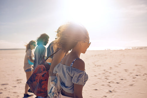 Friends walking along the beach on a sunny day