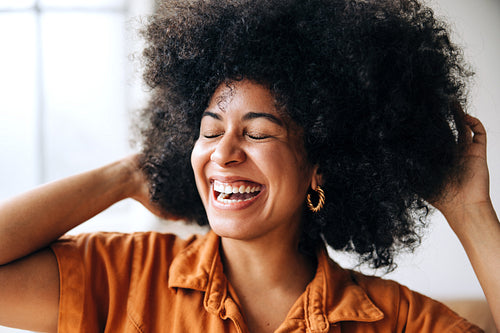 Happy businesswoman with Afro hair smiling with her eyes closed