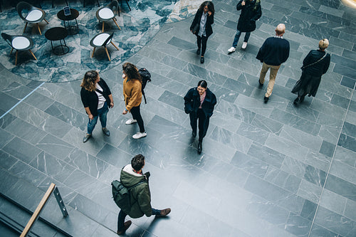 Business people walking across office lobby