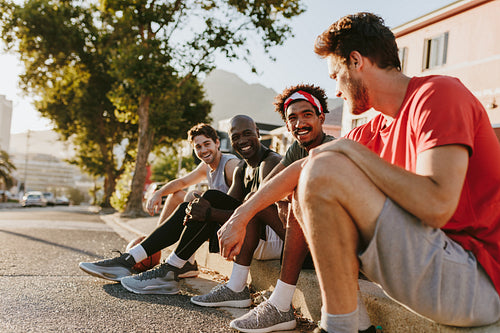 Athletes sitting on the pavement and talking