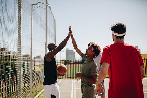 Men playing basketball in basketball court