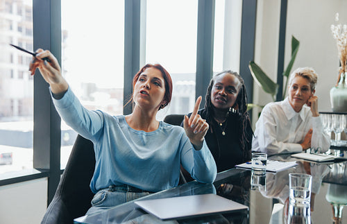 Young business woman presenting her ideas to her team in a meeting