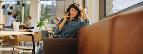 Freelancer speaking on cell phone in coworking space