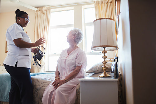 Female doctor visiting her senior patient at home