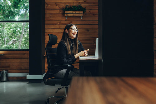 Smiling female entrepreneur having a video call in a coworking s