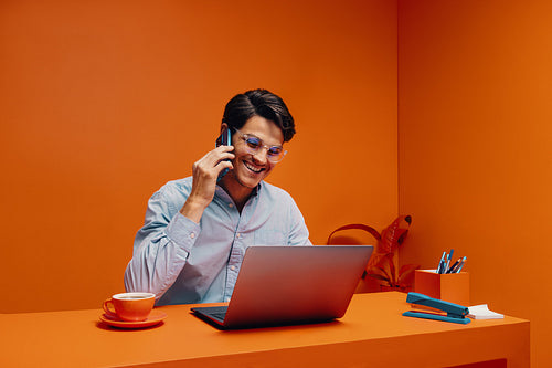 Manager in monochromatic office concept using smartphone and laptop