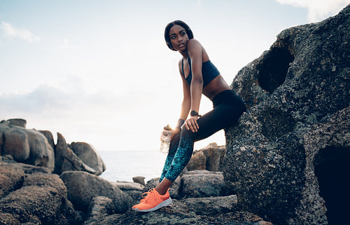 Fitness woman resting over a rock after workout