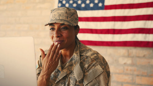 Soldier blowing kisses over a video call as she connects with her family from the military