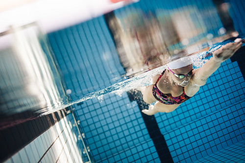 Female swimmer in action inside swimming pool