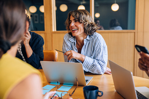 Cheerful businesswoman engaging in a successful team meeting and discussion
