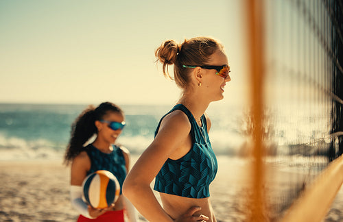 Summer games: Female pro volleyball match at coastal beach with athletes