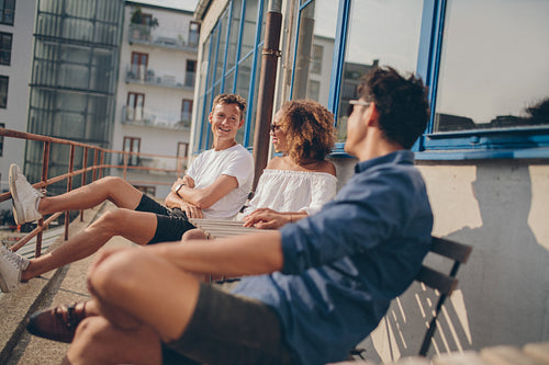 Three young friends relaxing at outdoor cafe