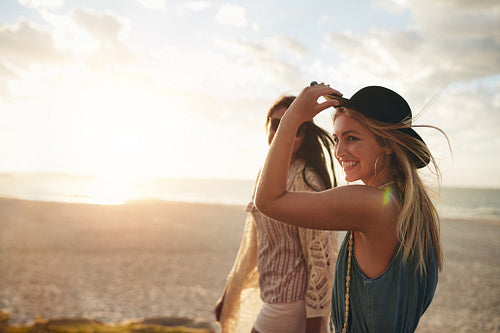 Beautiful friends enjoying a walk on the beach