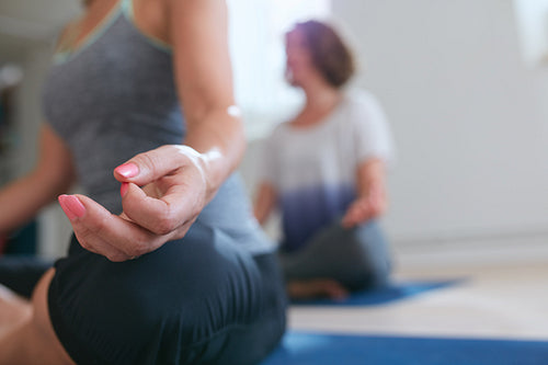 Meditating woman’s hand during yoga class