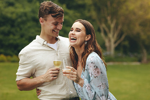 Beautiful couple in love with champagne at park