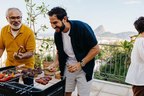 Family enjoying a barbecue on a balcony overlooking a scenic landscape