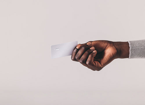 Man pays with his platinum credit card, holding it out to make a cashless transaction