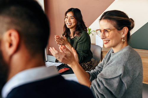 Cheerful businesspeople applauding during a meeting