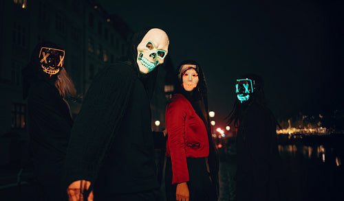 Group wearing glowing masks during a mysterious night in the city