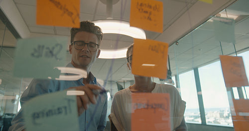 Discussion over sticky notes on glass wall