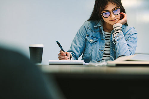 Girl student making assignment at university library