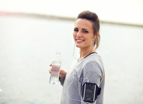 Smiling Female Runner Holding a Bottled Water