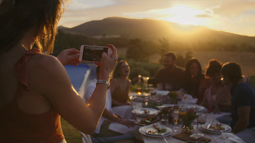 Woman capturing beautiful moments of dinner party