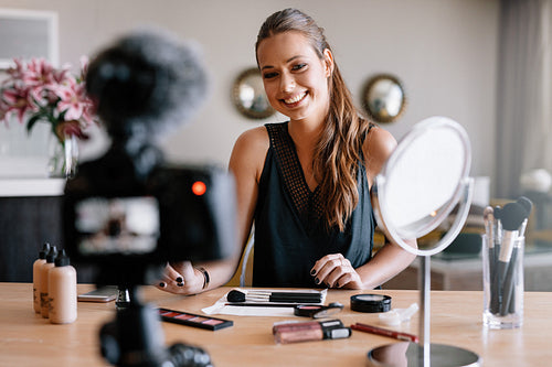 Female blogger recording video for her vlog on beauty and fashion theme.