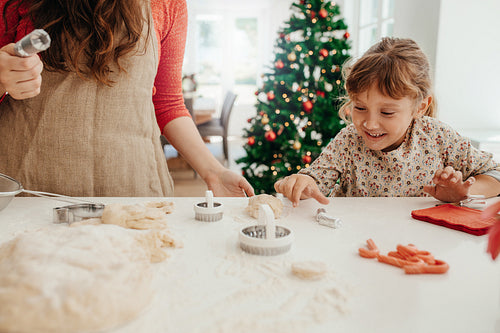 Mother and daughter making cookies for Christmas.